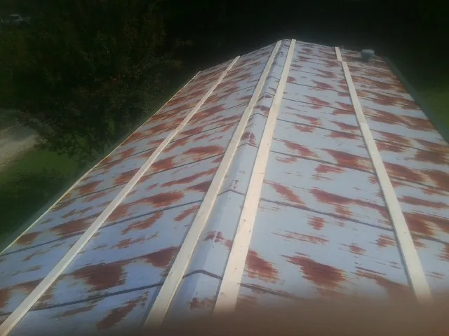 Rusted metal roof panels with new wood purlins before replacement — Storm Damage Roof Repair in Johnsonburg by Roofing Brothers